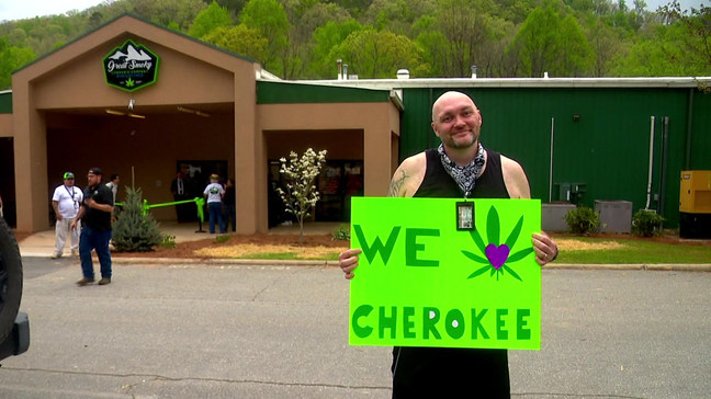Casey Stuart holds a sign outside of Great Smoky Cannabis Dispensary on its opening day on April 20, 2024. Stuart was among those in line to see inside North Carolina's first medical cannabis dispensary. (Photo: WLOS Staff)